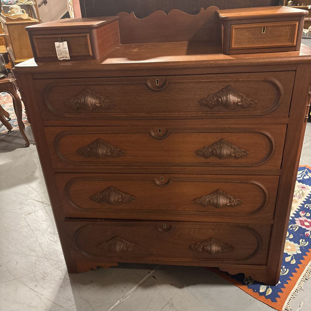 Victorian walnut chest of drawers; step back top with glove drawers, and heavily carved pulls. Circa 1870s